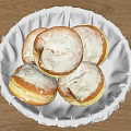 Fresh Round Powdered Sugar Pastries In White Cloth Lined Basket On Wooden Table