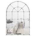 Arched Iron Frame Mirror in Bedroom Reflecting Bed Nightstand and Wooden Floor