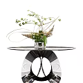 Elegant Console Table with Round Glass Top and Black Metal Frame Featuring Green Plant Arrangement