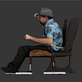 Man Sitting On Chair With Blue Floral Shirt Gray Hat And Electronic Devices