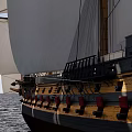 Traditional Wooden Sailing Ship Sailing On Calm Sea With White Sails And Blue Sky