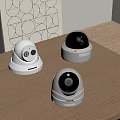 Three Different Surveillance Camera Models Placed On Wooden Table For Security