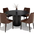Round Black Dining Table Set With Brown Leather Chairs And Vase With Dried Flowers