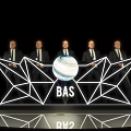 Modern Reception Desk with Five People in Suits Behind Geometric Light Design BAS Logo and Globe