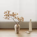 Golden Leaves Branch In Textured Vase With White Sculptural Bottle On Wooden Floor