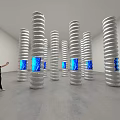 Art Installation Featuring Spiral Columns With Blue Illuminated Interiors In Gallery Space
