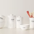 Neatly Arranged White Kitchen Utensils With Bowls Canisters And Spatulas On White Background