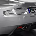 Silver Sports Car Parked In Indoor Space With White Walls Metal Roof And Tire Tracks