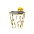 Round Side Table with Golden Curved Legs Black Tabletop and White Bowl of Yellow Lemons