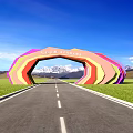 Multicolored Arched Entrance Gate with Rainbow Design and Green Fields Along Long Road