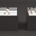 Black Display Cabinets With Glass Tops Showcasing White And Gold Decorative Items