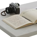 Vintage Camera With Open Book And Notebook Displayed On Tabletop Surface 3d model