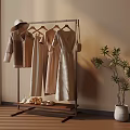 Stylish Clothes Rack With Hanging Dresses Hat And Shoes Near Potted Plant