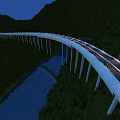 Illuminated Modern Bridge With Traffic Lanes Over River In Mountainous Green Area