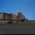 Modern Office Building With Glass Facade Parking Area Entrance And Blue Sky View