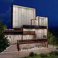 Modern Architectural Building With Illuminated Glass Windows Stairs And Surrounding Trees At Night