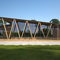 Modern Wooden Visitor Center With Large Glass Windows And Green Lawn Trees