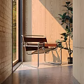 Stylish Leisure Chair With Metal Frame And Leather Seat By Wooden Wall And Plant