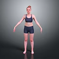 Woman Standing in Dark Sports Bra and Shorts with Arms Outstretched on Gray Background