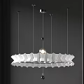 Modern White Chandelier with Wave Design Hanging from Metallic Cables on Dark Wall
