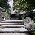 Natural Stone Stairs In Outdoor Garden With Lush Greenery And Rocks