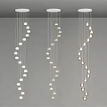 Three Modern White Chandeliers With Hanging Pendant Lights On Gray Ceiling