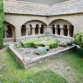 Ancient Stone Courtyard With Arched Portals Central Lawn Lush Bushes And Trees