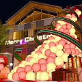 Giant Christmas Tree Balloon Decoration With Gift Boxes And Merry Christmas Sign Outside Building At Night