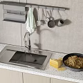 Stainless Steel Kitchen Sink with Faucet Drain Rack and Hanging Utensils on White Countertop