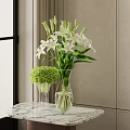 White Lilies and Green Hydrangeas in Transparent Vases on Marble Tabletop with Light Colored Walls