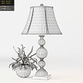 Ivory Lampshade Table Lamp with Glass Globe Base and Green Plant against White Wall Paneling