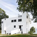 White Modern Vacation Rental Building Surrounded by Trees With Ocean View and Sky