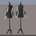 Two Black Mannequins Wearing Sequined Dresses With White Arms On Stands