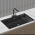 Black Kitchen Sink with Metal Drainer Rack and Faucet on White Countertop with Wooden Cabinets