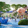 Children's Play Area with Spiral Slide Orange Dome Blue Play Floor and Green Trees
