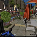 Vibrant Commercial Street With Outdoor Dining Seats Pedestrians Green Plants And Modern Shopfronts