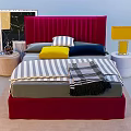 Double Bed with Red Velvet Headboard Striped Bedspread Colorful Pillows Plaid Blanket and Bedside Lamps