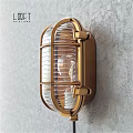 Brass Industrial Wall Sconce with Metal Cage and Glass Shade on Textured Wall