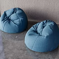 Two Comfortable Blue Bean Bag Chairs on Gray Floor Against Gray Wall Interior