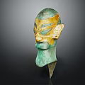 Ancient Greenish Bronze Mask Featuring Golden Accents And Intricate Facial Details