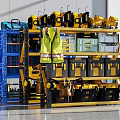 Organized Workshop Tool Storage With Yellow Toolboxes Blue Shelving And Safety Vest