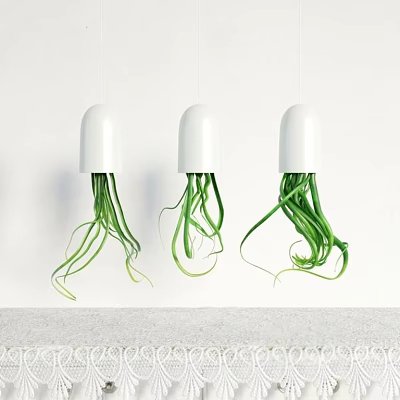Stylish White Hanging Planters With Long Green Leaves Hung On White Wall Below Gray Countertop 3d model