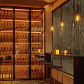 Bar Interior With Liquor Bottle Shelves Bar Counter High Stools Warm Lighting And Decorative Wall