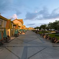 Traditional Chinese Commercial Street With Yellow Roofs Green Umbrellas And Outdoor Dining Areas