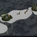 Modern Tea Break Area Featuring Curved White Tables Green Plants And Snacks