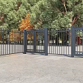 Black Metal Fence With Gates In Outdoor Area Surrounded By Green Trees