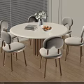Round White Dining Table Set with Six Wood Leg Upholstered Chairs Vase Flowers Books Fruit