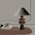 Wooden Base Table Lamp With Beige Fabric Shade On Table With Books Mug And Candle