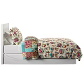 Double Bed With White Frame And Colorful Floral Bedspread And Pillows