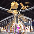 Large Gold And Silver Metal Art Installation With Golden Leaves Purple Light In Mall Interior
